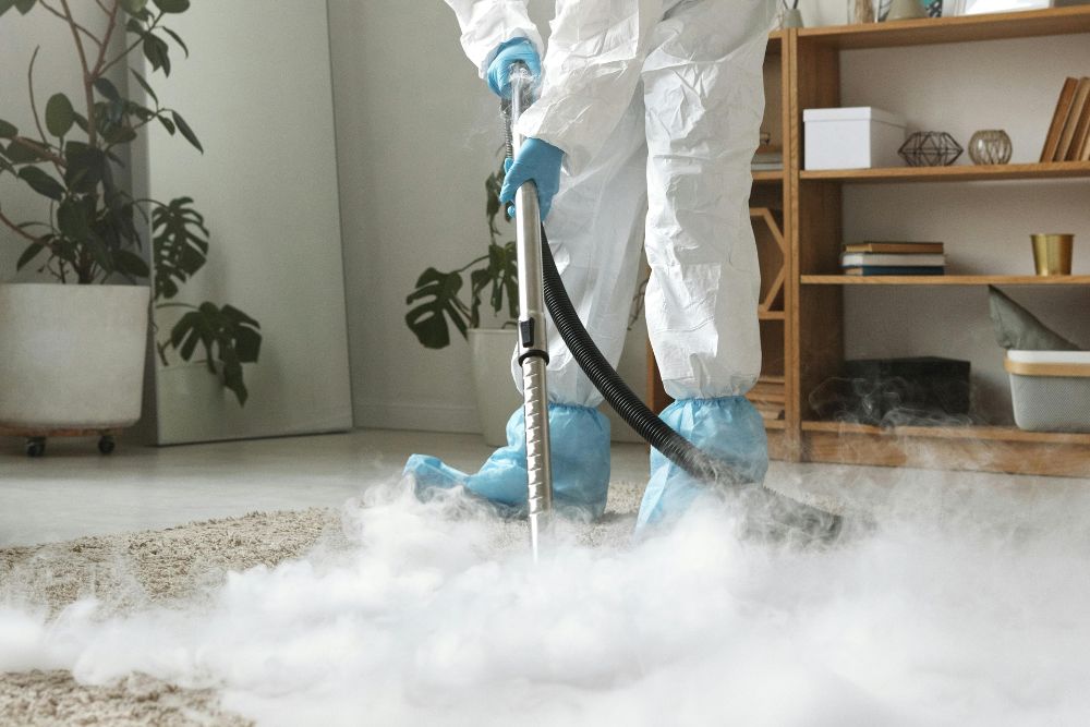 A person in a white coat and blue gloves is seen cleaning a carpet, highlighting a protection service in Springfield, IL.